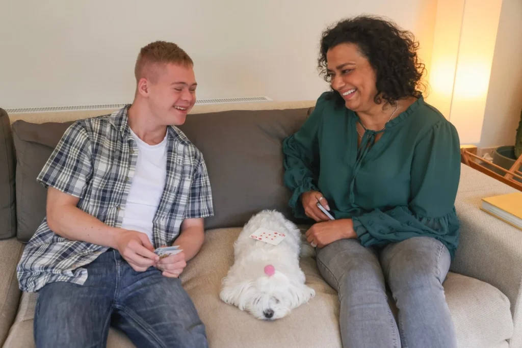 Support worker smiling with disabled boy with down syndrome