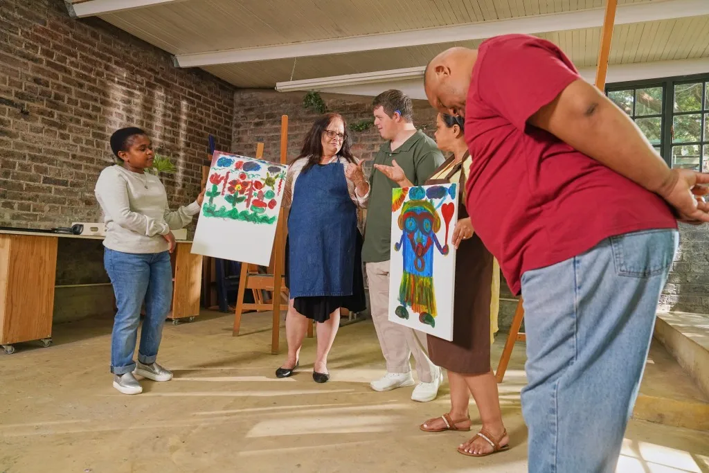 Disabled group of people with support worker in art class